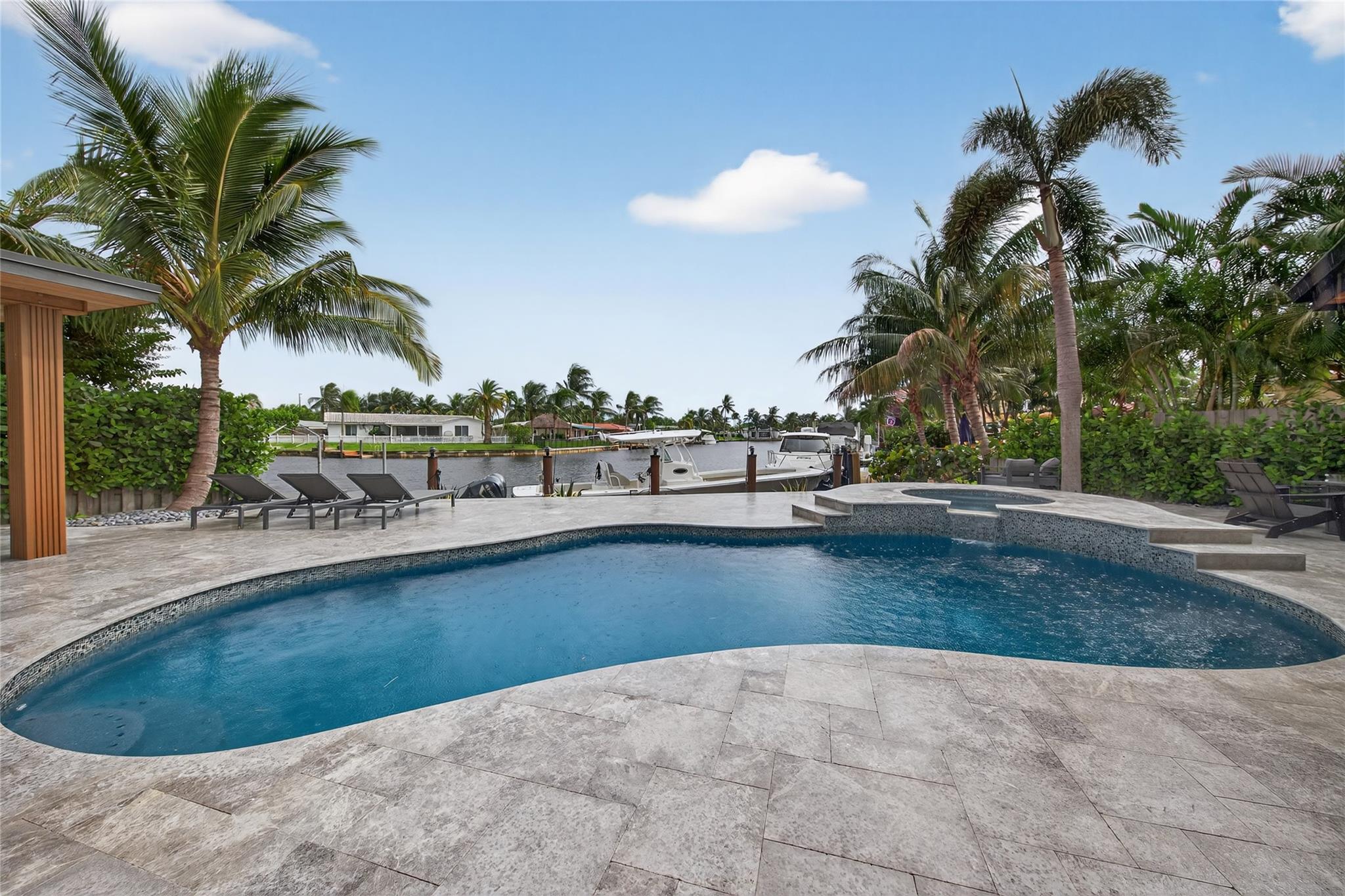 Welcome to this truly unique Waterfront Paradise in Garden Isles. This furnished and modern sanctuary offers an exceptional coastal lifestyle in the heart of Pompano Beach, ideal for a tenant who demands the highest quality. Features include 60 feet of seawall with unobstructed canal views, private dock, an expansive travertine patio, a refinished heated pool and spa and a fabulous outdoor kitchen. The interiors boast luxury finishes, large profile tile, custom cabinetry, and premium upgrades like full impact windows and electric privacy shades. The private primary wing is a resort-inspired escape with a curbless shower, soaking tub, and custom walk-in closet. The home also includes a fully equipped garage gym. True South Florida Living! Available now for lease, 6 months to 1 year.