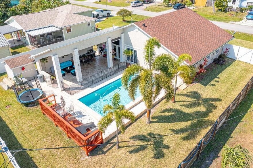 WELCOME HOME to this fully updated POOL HOME conveniently located in the heart of Port St. Lucie! BRAND NEW ROOF! NO HOA! This home is move in ready and has it all! 3 bedrooms, 2 bathrooms, 1 car garage with expanded driveway for extra parking for your boat, RV, or both! Upon entering the home, you'll notice the cedar plank volume ceilings, as well as an open living concept going into the amazing kitchen! Gas stove, skylights, quartz countertops are all a part of this updated kitchen! The backyard is a true TROPICAL OASIS, with a huge covered patio leading to the pool, great for entertaining! This home also has IMPACT WINDOWS throughout! Home also has security cameras and sensor system free of monthly payments! Just 15 minutes to the beach!