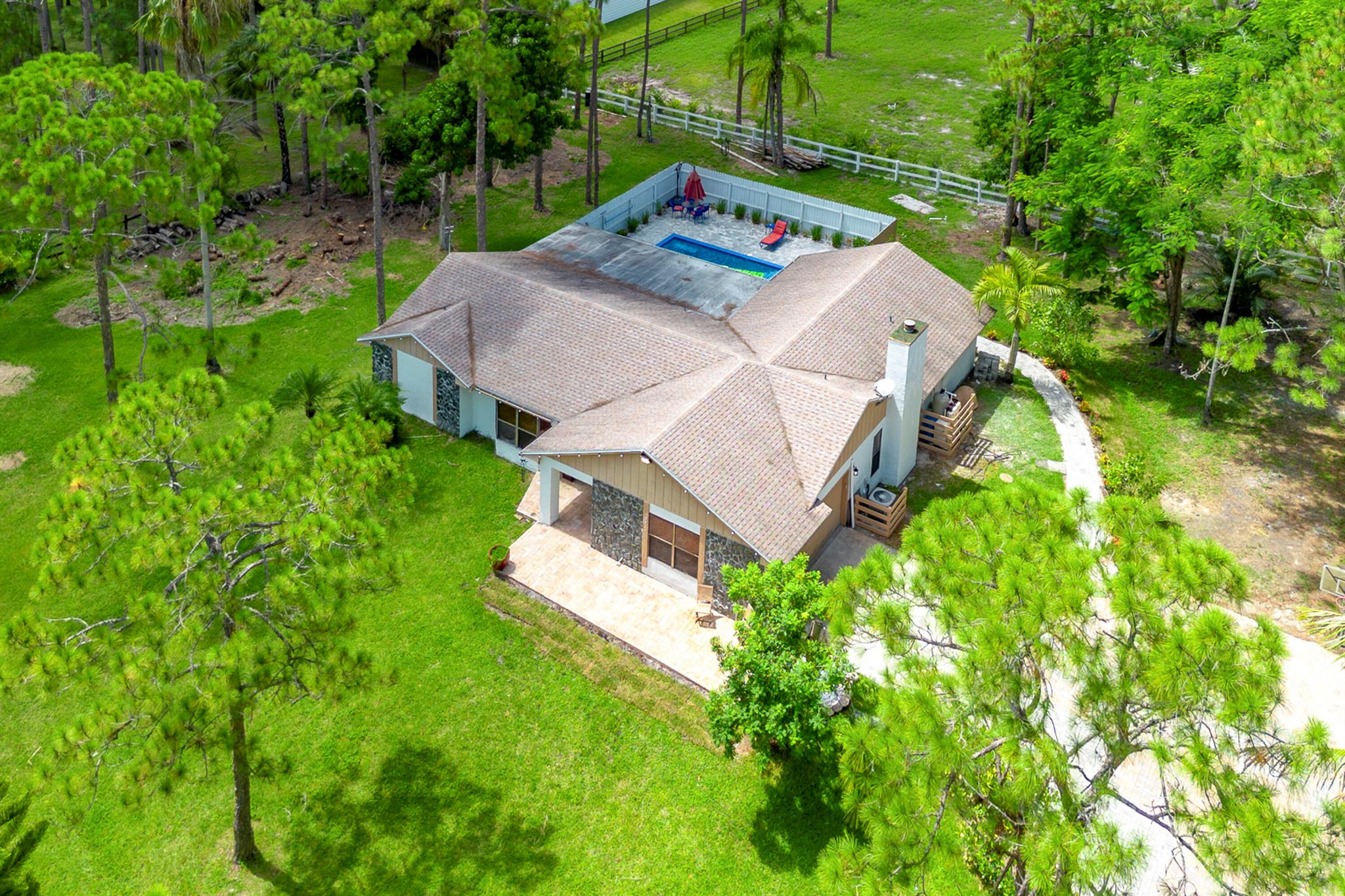 Stunning fully renovated 3BR/2BA + office single-family home on 1.3 gated acres with NO HOA! New heated saltwater pool with sundeck, covered patio, new pavers throughout property. New RO system and Roof under 4 years old! Interior upgrades include paint, new flooring, new cabinets, new SS appliances, and completely updated bathrooms. Has a working fireplace, metallic epoxy garage floors in the 2-car garage, and gated dual entrances. The expansive lot includes 3 sheds, a dog kennel, chicken coop, and a brand-new well. Plenty of room to live, work, and play--move-in ready! This property offers the perfect blend of privacy, modern finishes, and functionality, this home checks all the boxes. Rare opportunity to own a fully upgraded home with land and freedom, bring your chickens and toys!