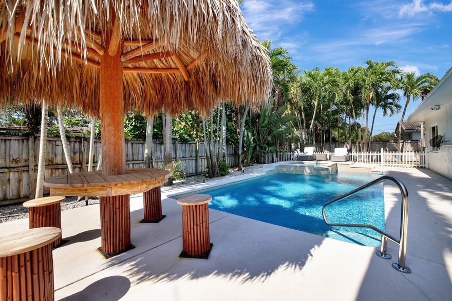 New price reduction.  Rock bottom price! Relax by the pool in a private yard with Tiki Hut. This spacious open concept home is move-in ready. Bright & modern, tile throughout with 3 bedrooms and 2 full bathrooms. Both bathrooms fully updated in 2022. Large eat-in kitchen is a chef's dream, boasting new Quartz countertops, stainless steel appliances, and white wood cabinets with ample storage. High quality Impact windows & doors throughout. Newer 2022 A/C. The covered patio and garage have durable custom epoxy floors that are easy to clean. Fenced yard provides separate area for pets or garden. Tiki Hut, pool pump, refrigerator and microwave installed 2022. Washer & Dryer 2021. Water heater is 2019. Garage is attached with Circular driveway.