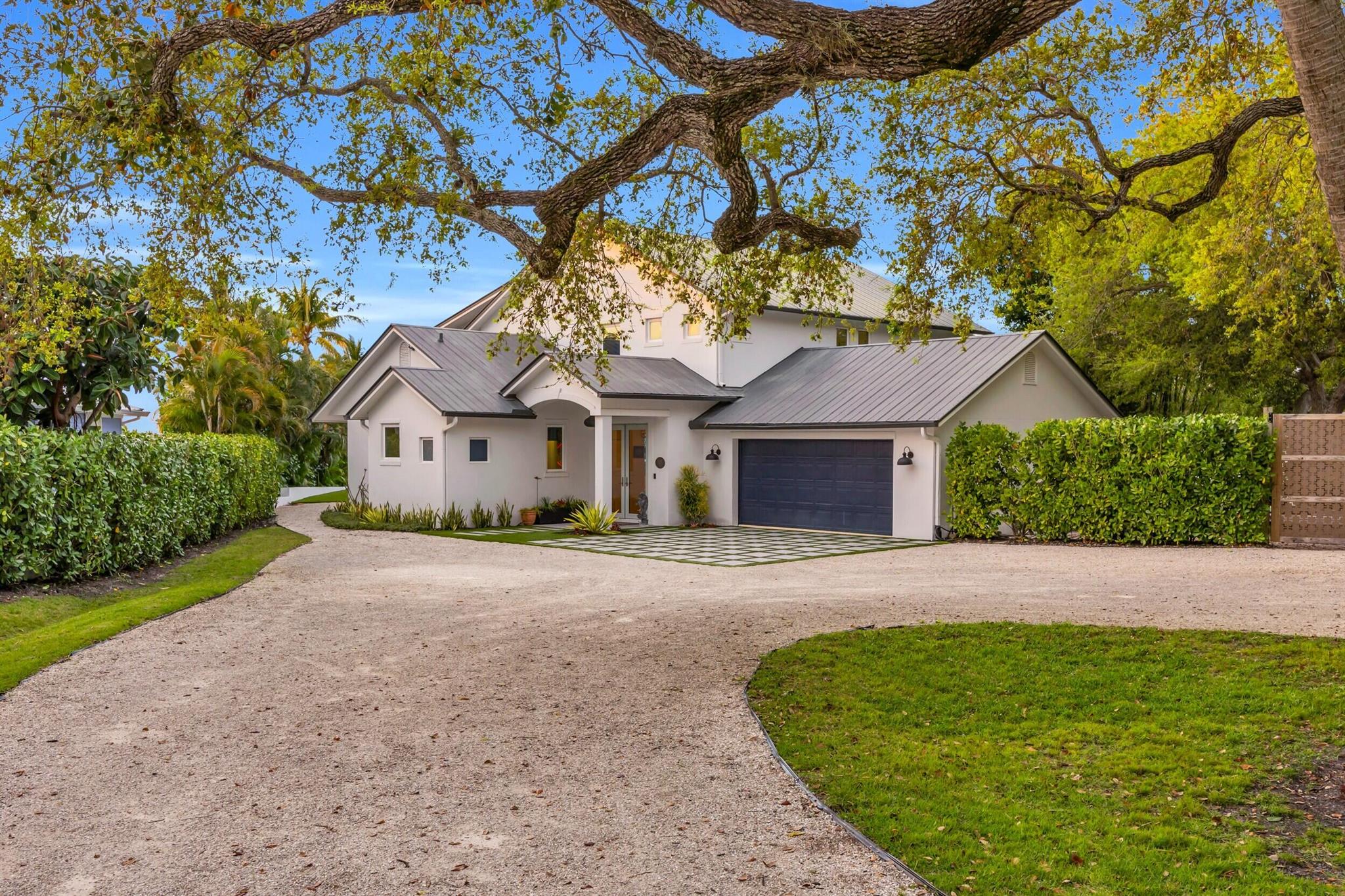 Welcome to your private waterfront retreat, where modern luxury meets serene coastal living. The home was completely renovated in 2022, rebuilt upgrades to the two master suites. Floor-to-ceiling windows fill the space with natural light to view backyard and waterfront view. The open-concept design connects the gourmet kitchen, living areas, and outdoor spaces, perfect for relaxation and entertaining. High-end finishes and appliances throughout. 98' feet of waterfront access, two boat lifts. The primary suite features a water view balcony and luxury bath. Located at the mouth of Poppleton Creek, 2 Boat lifts; 30,000 and 7,000lb,100' dock, Impact Glass Windows, Built in Garage Cabinetry, 1/2 acre+ estate lot, Circular Driveway