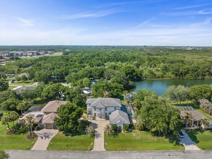 Exclusive gated community. This lakefront estate offers 4 bed, 3 full & 2 half baths, an office, 3-car garage & water views. Including a stunning stone fireplace & custom stone staircase. The gourmet kitchen features white wood cabinetry, Bosch double ovens, prep sink & generous workspace. Including a primary suite w/ a private sitting area & spa-inspired bath w/ beautiful Jerusalem tile. Private backyard retreat complete w/ gas-heated pool & spa, outdoor kitchen & expansive entertaining space overlooking the tranquil lake. Additional features include a 2018 roof, dual-zone A/C systems (2018 & 2021), natural gas pool heater, three tankless water heaters, impact-resistant doors & new windows, custom fingerprint access front door & all mounted TVs included.