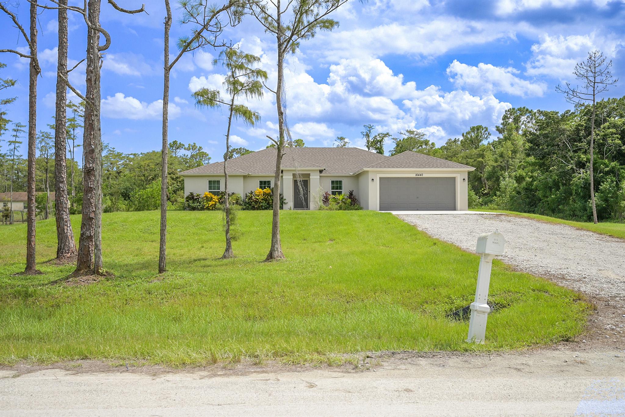 Awesome Acreage Home! 2022-constructed, Single Story, 4-bedroom 2 Full Bathroom split bedroom CBS home situated on an elevated 1.14-acre lot! Open Floor plan offers lots of light and vaulted ceilings. Impact windows and doors. Gourmet Kitchen with energy efficient SS appliances, White cabinets and center island for entertaining. The home boasts a Water filtration system. Tile flooring throughout the house. 2-car garage. Owners' suite features huge walk-in closet, gorgeous bathroom with separate tub and shower, dual sinks. The Acreage is known for their generous acre plus sized lots, proximity to Downtown West Palm Beach, Westlake and Palm Beach Gardens Shopping, close to Palm Beach Internatioanl Airport and most of all NO HOA or restrictions-so bring your Pets RV, Boat, Trailer and TOYS!