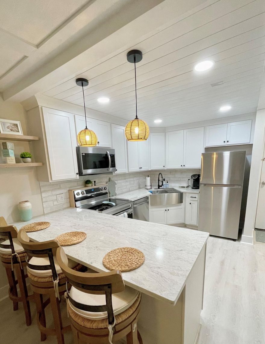 Completely renovated and move-in ready 1BR/1BA condo in the highly desirable Ocean Village community! This beautifully updated second-floor unit offers a bright, coastal-inspired interior with luxury vinyl flooring throughout, a modern kitchen featuring quartz countertops, stainless steel appliances, and a spacious island perfect for entertaining. The open-concept living area flows seamlessly into a stylishly furnished space with coffered ceilings and designer lighting, creating a true beach retreat feel. The updated bathroom showcases a sleek glass-enclosed shower and contemporary finishes, while the spacious bedroom offers comfort and functionality. Additional highlights include in-unit washer/dryer, custom built-in features, and a convenient workspace nook Ocean Village is a gated, resort-style oceanfront community offering private beach access, 9-hole golf course, multiple pools, tennis, pickleball, bocce, on-site restaurant, clubhouse, and 24-hour security.  Perfect as a primary residence, vacation home, or investment opportunity. Enjoy the ultimate Florida coastal lifestyle!