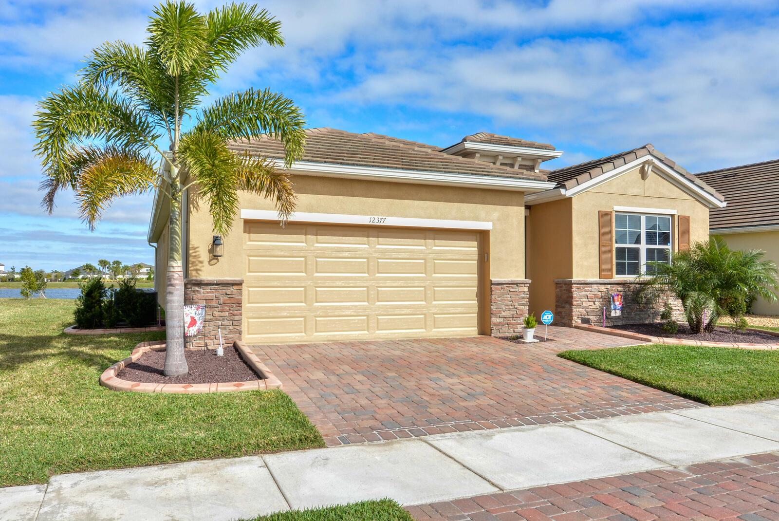 Welcome Home to this amazing eco-friendly / energy efficient smart home located in the gated and secure private community of The Preserves / Estates of Tradition. This pristine 4BD, 2BA, 2-car garage single family home, situated on the lake, provides stunning sunrise views as well as picturesque sightings of jumping fish and water fowl from the expansive back patio where tranquil tropical breezes abound. The open floor plan is accentuated by the exquisite white granite kitchen counter tops with Breakfast Bar; ceramic tile throughout the main living areas; SS appliances; ceiling fans and decorative lighting. The Owners suite boasts dual vanities, large wall mirror, walk in shower and water closet. Additional upgrades have been added and include the painting of the exterior and much of