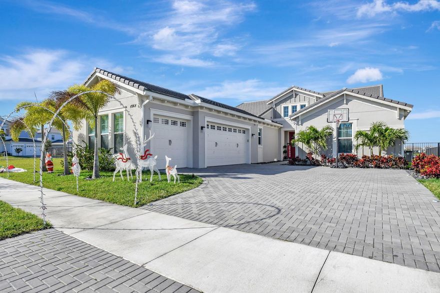 Single-story Contemporary Florida home with a transitional interior, set on one of the most desirable lakefront lots in The Orchards at Westlake! This Sandhill model offers approximately 100 feet of water frontage, a private heated pool, fully fenced backyard, and an oversized side yard! The open floor plan features porcelain tile flooring, a large kitchen island with pool and lake views, breakfast nook, and a formal dining room! Gas service supplies the kitchen range and water heater. The three-car garage includes a finished epoxy floor, with an indoor laundry room nearby. Three well-proportioned bedrooms + Den include a primary suite with lake views. A rare combination of lot size, water frontage, and functional single-story living!