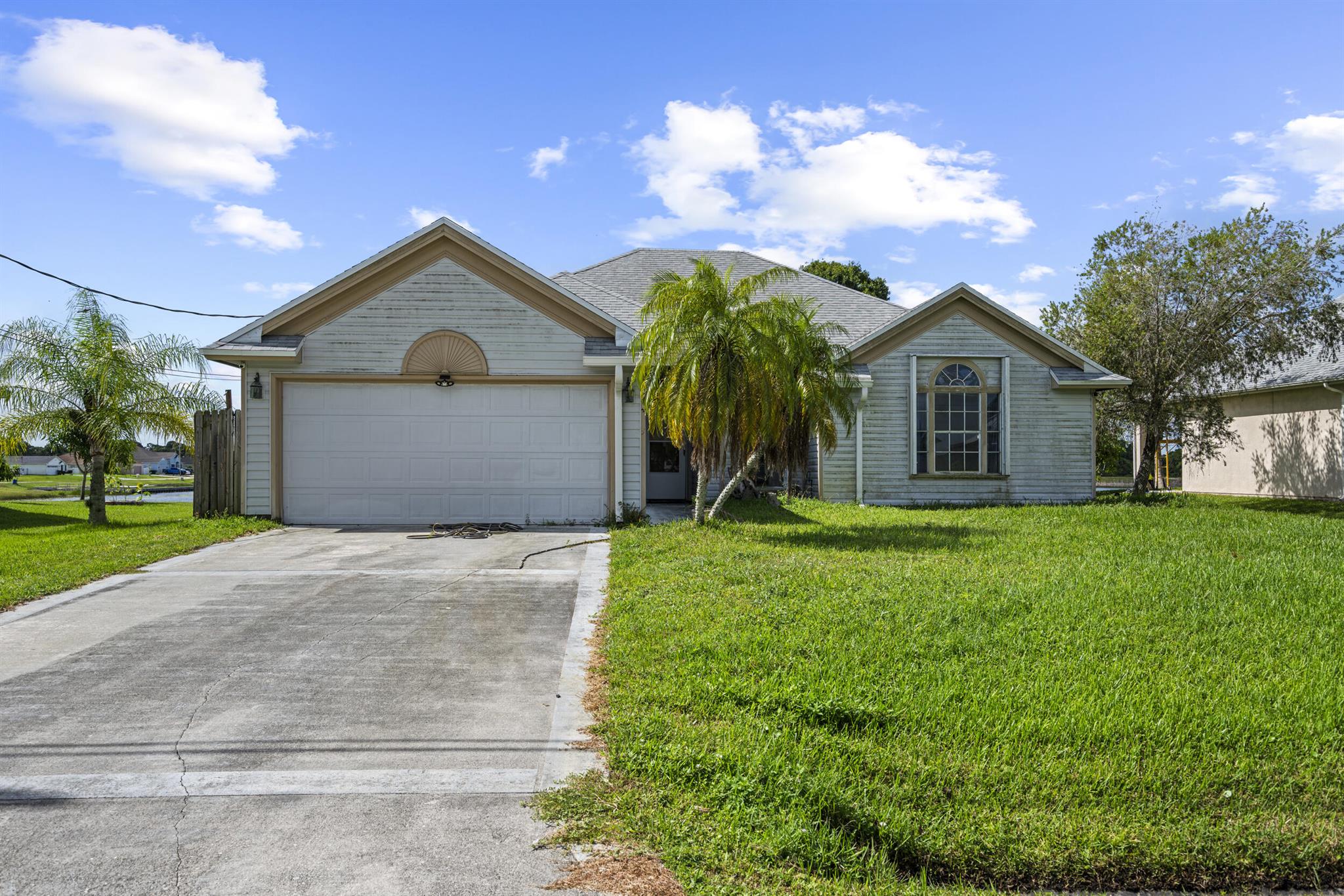 This charming 3-bedroom, 2-bath ranch home with a peaceful lake view is a true opportunity for buyers who want both value and potential. Perfectly situated near the Tradition area and free from HOA or CDD restrictions, it provides flexibility and long-term savings that are hard to find. Major updates are already taken care of, including a new roof (2022), transferable solar panels for energy efficiency, newer kitchen appliances, washer and dryer, a new air conditioning system, and a new water heater--giving you peace of mind where it matters most. Inside, the split-bedroom layout, volume ceilings, and open kitchen with snack bar and breakfast nook create a bright, functional space with plenty of room to grow. While it could use a touch of TLC, the home's strong foundation and modern ...