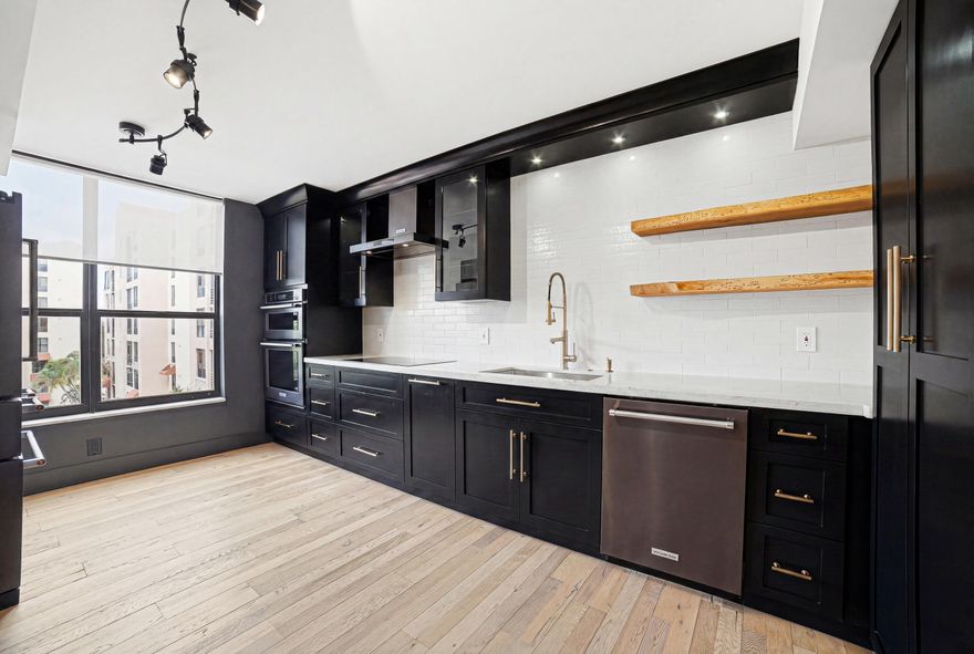 Prestigious gated community of Boca Pointe, fully redesigned, interior designer residence offers luxury. Engineered hardwood floors lead to a Taj Mahal quartzite kitchen with custom solid wood cabinetry, live edge shelves, and matching KitchenAid appliances. Bathrooms feature quartz counters and marble mosaic floors. The guest bath includes a petrified wood vessel sink, while the primary suite offers dual shower heads, a quartz bench, Grohe fixtures, and an LED/Bluetooth ventilation system. Mobility friendly enhancements include smooth, wide pathways, low transition flooring, and designer grab bars in the primary suite. Additional upgrades include solid wood doors, designer lighting, custom millwork, organized closets and 2026 washer/dryer. Optional club membership completes the lifestyle.