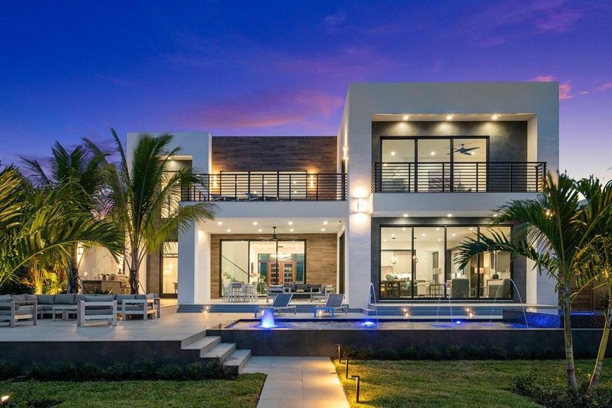 This spectacularly designed direct intracoastal estate is located along a prime No-Wake zone, just a short walk to the Beach and Deerfield's shops and restaurants. Every detail of this stunning home has been meticulously planned, perfect for entertaining or as a private retreat. An expansive kitchen with high-end appliances, sixteen-foot island, a butler's pantry, and endless views. Vast open spaces with volume ceilings, and water views at every turn.  Outside, you'll find a full summer kitchen and a sparkling saltwater pool, complete with deck-jets, bubblers, and sun shelf to round out your private resort. A T-dock with lift is perfect for housing all of your water toys just a short ride to Lake Boca and The Boca Inlet. Take the elevator or stairs to the second floor media loft, and four upstairs bedrooms, each ensuite. The grand master suite features dual balconies accessible through floor-to-ceiling glass doors, custom built closets, a morning bar, and oversize bathroom with shower and free-standing tub.