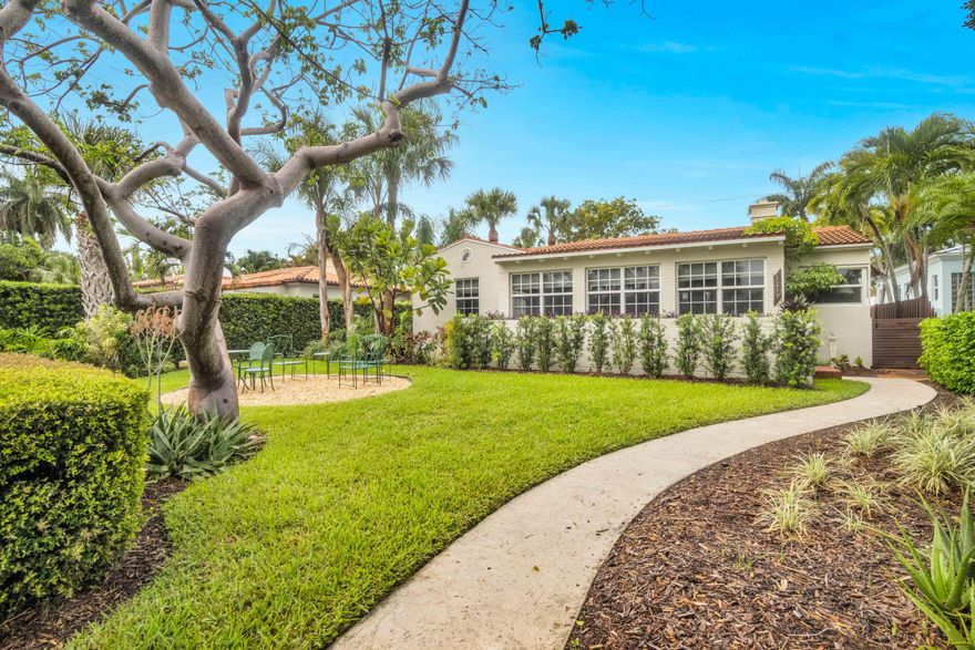 Charming historic CBS home in sought-after Parrot Cove, designed by noted architect Edgar S. Wortman, with golf course and Intracoastal views from the front yard. Set on a picturesque tree-lined street, this beautifully maintained residence blends timeless character with thoughtful details throughout. Features include a 2021 30-year roof, impact windows and doors, updated electric service, whole-house 20KW natural gas generator, gas on-demand water heater, and a classic kitchen with granite countertops, new gas range, and office nook. Original Miami-Dade hardwood floors add warmth and charm, while the primary bath offers a Japanese soaking tub and the living room features a working fireplace.  The detached garage with electric and full bath offers endless flexibility as a guest suite, art studio, office, or workshop.  Situated on an oversized lot overlooking the Lake Worth Beach Golf Club, this exceptional home is just moments from the beach, Intracoastal, vibrant downtown Lake Worth Beach, restaurants, shops, and more. Enjoy the best of South Florida living with no HOA—walk to golf, lunch, downtown events, or the ocean from one of the area's most beloved historic neighborhoods.