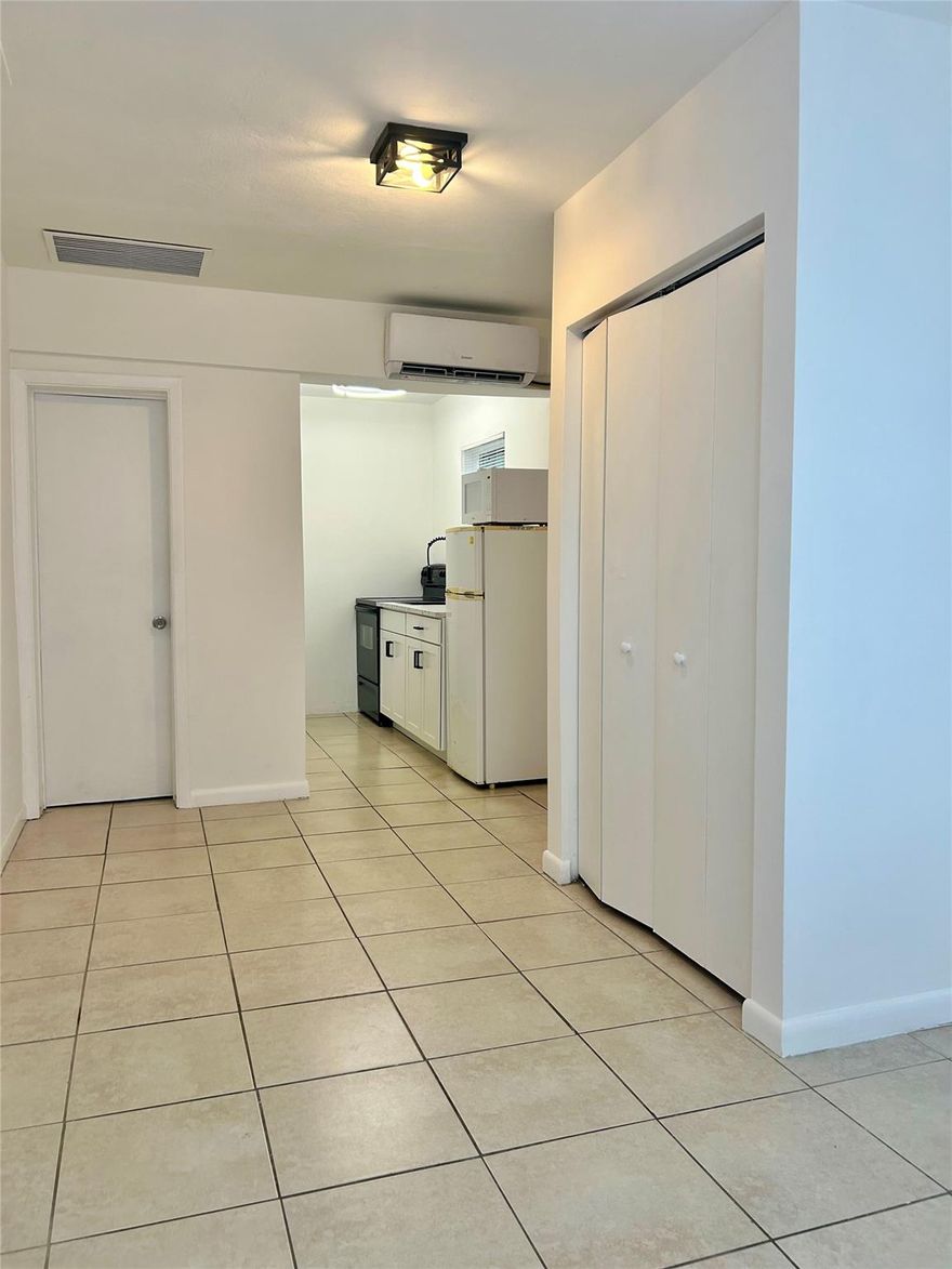 Freshly painted in crisp white, this luminous efficiency, attached to main house, features a brand-new kitchen with updated cabinets and countertop, plus essential appliances including new refrigerator, oven, and microwave. The space offers modern comfort with updated air conditioning, ceiling fans, and abundant natural light. Two convenient parking spaces. Electricity, water and sewer included in the rent. No condo approval needed. Ready to move in. Centrally located in a nice and quiet area.