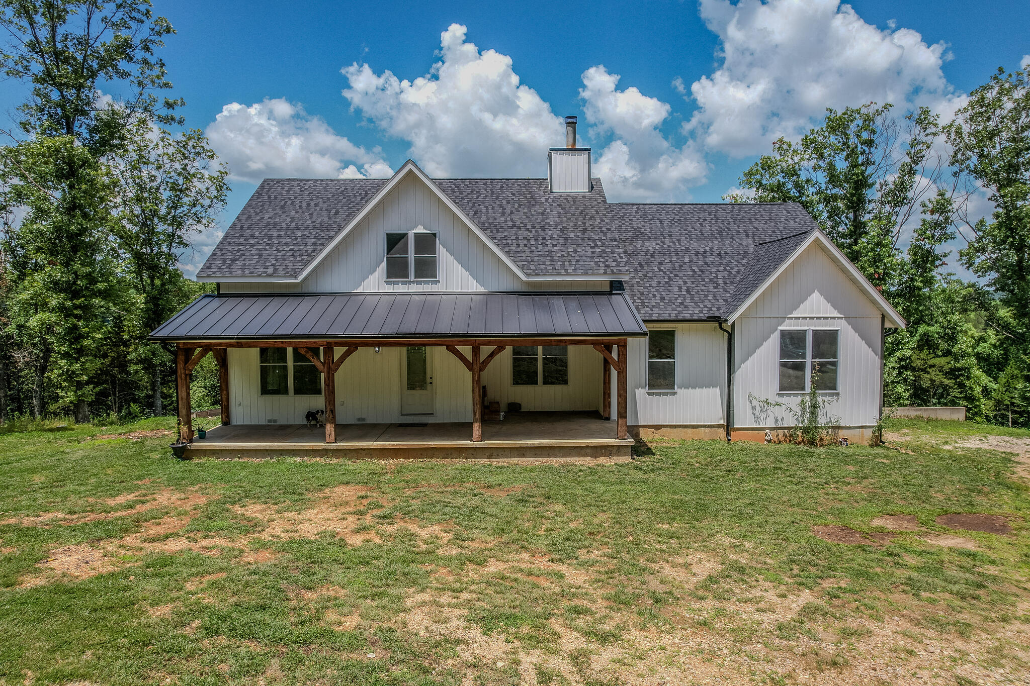 Beautiful large family home sitting on 69+ acres of wooded ground with access to more than 2,000 of Osage fork river access at your back door! This one of a kind property has a long private drive back to a farmhouse style home built in 2021 with river access just behind the home. The home features real hardwood floors throughout the main level with a completely open concept and large vaulted ceilings. This custom home has so many great features with the large kitchen and island for seating, butcher block counters, pantry area and under cabinet lighting. There is space for a dining room table along with plenty of seating space in the living room and a wood burning fireplace. The master suite has tray ceilings, large windows for  natural light and a huge walk in closet with two doors. The on suite bath has a custom tiled walk in shower with bench seating, double sinks and a soaking tub. Bedrooms two and three are also on the main level along with a full size bathroom. Downstairs there is an additional bedroom along with a second living space, kitchen and dining area and a large covered back patio. Outside living space is phenomenal with a large covered back deck overlooking the Osage fork river. This property is truly one of a kind and also offers an oversized garage with a single garage door, covered carport area and a small outbuilding. Come enjoy the warm summer days at the creek and wildlife that are abundant on the property.
