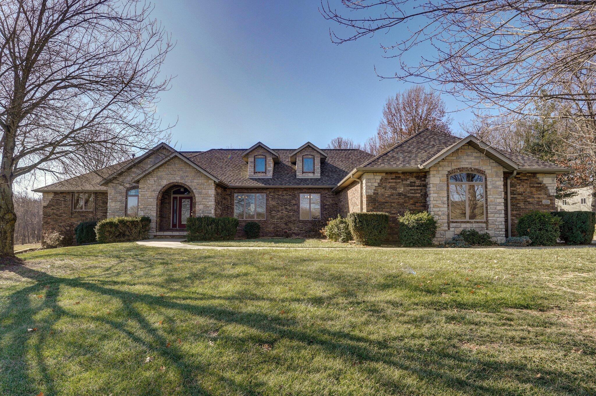 Welcome to this stunning all-brick home nestled on 18.1 acres in a small neighborhood that offers country living with modern conveniences. The home features a split bedroom floor plan with 5 spacious bedrooms & 4 full baths, 3-car garage plus impressive 34x72 outbuilding.From the foyer, notice the unique architectural details--arch windows & doorways, French doors to the office, stone wall coverings, warm wood tones & pillar accents. The main level boasts a formal living and dining room, kitchen overlooking the cozy hearth room, office with a fireplace, primary suite & 3 additional bedrooms. The large kitchen combines natural wood tone cabinets with granite countertops, tile backsplash & stainless steel appliances (fridge stays). The kitchen eating area provides a wonderful place to enjoy the outdoor scenery. The adjacent hearth room features natural beam work & a corner gas fireplace. The master suite features accented tray ceiling, two vanities, jetted tub, walk-in shower & closet. The expansive walkout basement features a large living area--with plenty of room for a sitting area & game table--a huge kitchen area with fridge, dishwasher & microwave, 1 bedroom & bath, and tons of additional storage space!!Step outside to the covered back deck where you can enjoy evenings by the firepit just down the steps, overlooking the quiet property. The large outbuilding provides ample room for projects, hobbies, or extra storage. Outbuilding measures at 34x72 with a 12' lean-to in the rear. Features include: 3 10x10 doors, insulated, heated and limited AC, LED lighting, 110 & 220 volt outlets plus all the storage racks stay! Updates and maintenance items include: new roof on home and shop 2023, Permaseal 25 deck treatment, water softener, air ducts cleaned 2024, new furnaces in 2018/2021. Bonuses: central vacuum, front and back lawn irrigation & dead-end road. This property provides plenty of space, inside and out, to make memories for years to come.