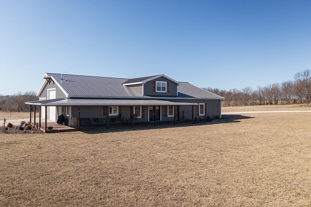 ACREAGE! Now available is this nicely appointed one-and-a-half story property just a couple minutes outside of town with blacktop county road frontage. Newly constructed in 2021, the home features a low-maintenance slab construction with many high-end finishes inside. Of these finishes are, custom oak cabinetry with large center island, custom walk-in tile shower, stainless appliances, pocket doors, amongst others. Sizable rooms throughout including 20x16 master bedroom. Similar to the bedrooms, the laundry room and pantry boast plenty of space in their own right. Perhaps the most appealing feature of this property is the 3040 +/- sqft. attached garage/shop area that is complete with 4 doors, spray foam insulation, several 220v's, & a sewer clean-out for 5th-wheel hookup. Additionally, the shop is serviced by the central heat & air while also offering two affixed ventless propane heaters if that's what you'd prefer. All of the 4 garage doors are oriented to accommodate a ''pull-through'' style garage with two of the doors being 16x14 to accommodate travel trailers or heavy equipment. Outside, there are additional RV hookups, two driveways for access off of either road, and a storage shed that has power, plumbing (including a second water heater), extra washer/dryer hookups, and houses 1 of the 2 pressure tanks that service the property.