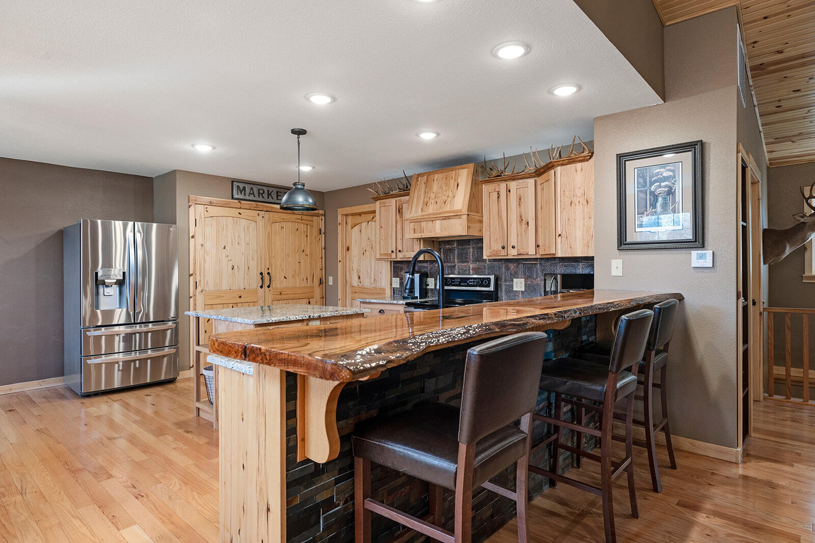 Charming Country Living with Modern Touches Discover the perfect blend of rural tranquility and modern convenience on this stunning 40+ acre property. This beautifully built home features 3 spacious bedrooms, including a non-conforming 4th bedroom, and 2.5 luxurious baths. The heart of the home is the stunning kitchen, complete with granite countertops, hickory custom cabinets, and a striking live edge red oak bar top ideal for extra seating. Enjoy the elegance of hardwood floors throughout. The fully finished walkout basement offers additional living space and versatility for your needs. With large bedrooms and modern, beautifully designed bathrooms, this home provides both comfort and style. Outside, you'll find a 16x24 shop, perfect for storage or hobby work. A two-car garage completes this serene country retreat. Bring your horses and cows or simply enjoy the abundant wildlife. Don't miss your chance to make this unique property your own!