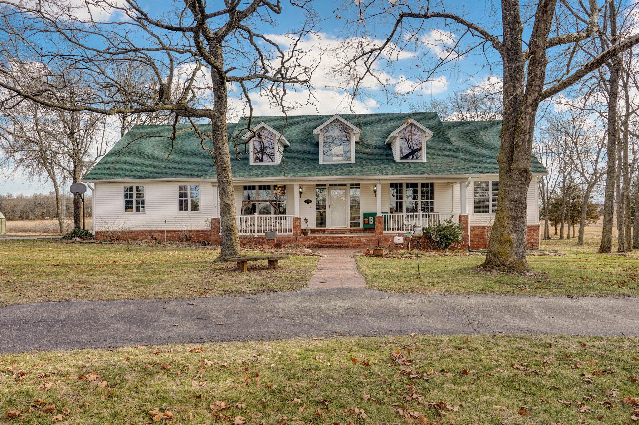 This one owner custom-built home sits on 90 acres. Forty acres of fescue produce two hay crops per year, and 25 acres of warm season grasses produce one. Twenty plus acres include trails with mature timber. There is a two acre wildflower plot for pollinators, and a 1/2 acre stocked pond with a dock forfishing. A separate well keeps it full when needed. Gardens and lawns around the home are watered by a WIFI based inground sprinkler system as is the 8' X 12' greenhouse and 10' X 40' shade house. The back deck is reinforced and wired for a hot tub, and includes a gazebo for shade. An inground pool was removed, but the electrical/plumbing remains to add your own pool. The patio leads to a fire pit area, outdoor shower, and an accessory building with its own bathroom, changing area, and shower plus a mini kitchen. The property includes a 30' X 40' pole barn with two 12' wide side lean-tos, one of which is perfect for an RV. Included is a whole house transfer switch to which you could add your own generator.You're greeted at the front door with a soaring 24' ceiling and custom oak timber frame beams, giving it a lodge-like look. The open floor plan is perfect for entertaining with granite countertops and custom-made hickory cabinets in the kitchen. A wood burning stove sits in the corner of the open concept living room.French doors off the living room open to a four-season porch. Stairs from the living room lead to an expansive finished basement. Bonus - the pool table stays! This home has 4 bedrooms and 3.5 baths.Storage is plentiful throughout the house, the basement, and stairs that lead to a big storage area above the 2-car attached garage.This property is located just south of Monett, Missouri, 40 minutes to Joplin, 45 minutes to Springfield, and an hour to the northwest, AR area. For fishermen you are 40 minutes from Table Rock Lake and 30minutes to Roaring River State park! Don't miss out on this one-of-a-kind property in Southwest Missouri!