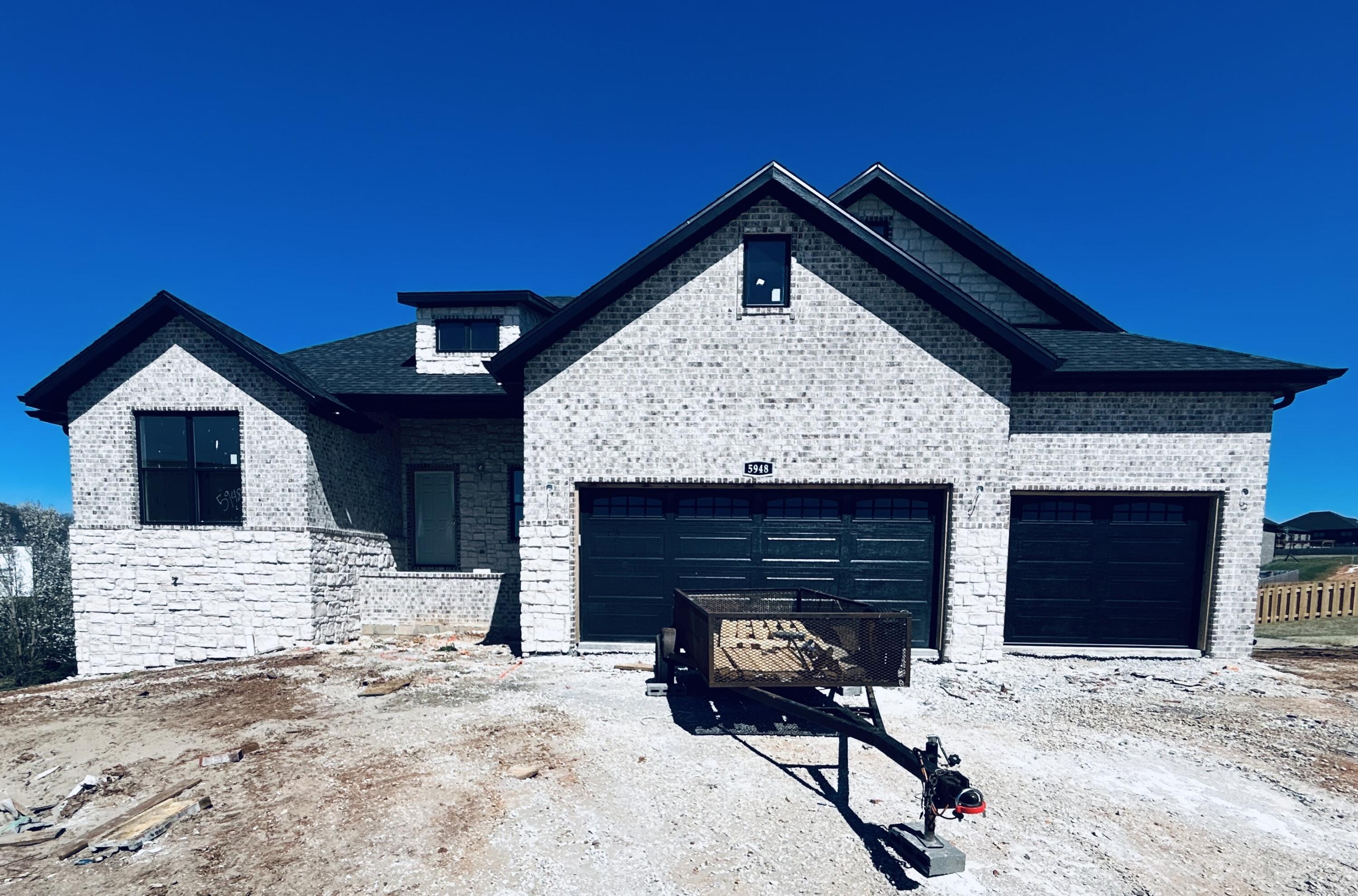 BEAUTIFUL, Brand new in (Gated) Lions Gate! Backs to trees! 5 BR , walkout basement! All brick/stone exterior with light flooring planned for master bedroom/ living room/kit/din/entry and hallways of main level. and on the stairs  Quartz countertops, Shiplap fireplace on the main level and in the rec room downstairs. Interior paint; City Loft. Appr 4000 Sq ft. Split BR design with laundry room access to MBR closet/tiled shower & soaker tub in master. Wooden shelving thru out . MBR closet has wooden shelving and built-in dresser. 3 BR's on main level with 2 additional in basement. Generously sized wet bar in basement. Family room in the basement will have fireplace with shiplap surround. Upgraded Stainless appliances with gas range& walk-in pantry in kitchen. Planned colors are: white cabinetry , white/subway tile/ backsplash with white grout, white farm sink,  tile in baths and laundry. Full sod, & irrigation .