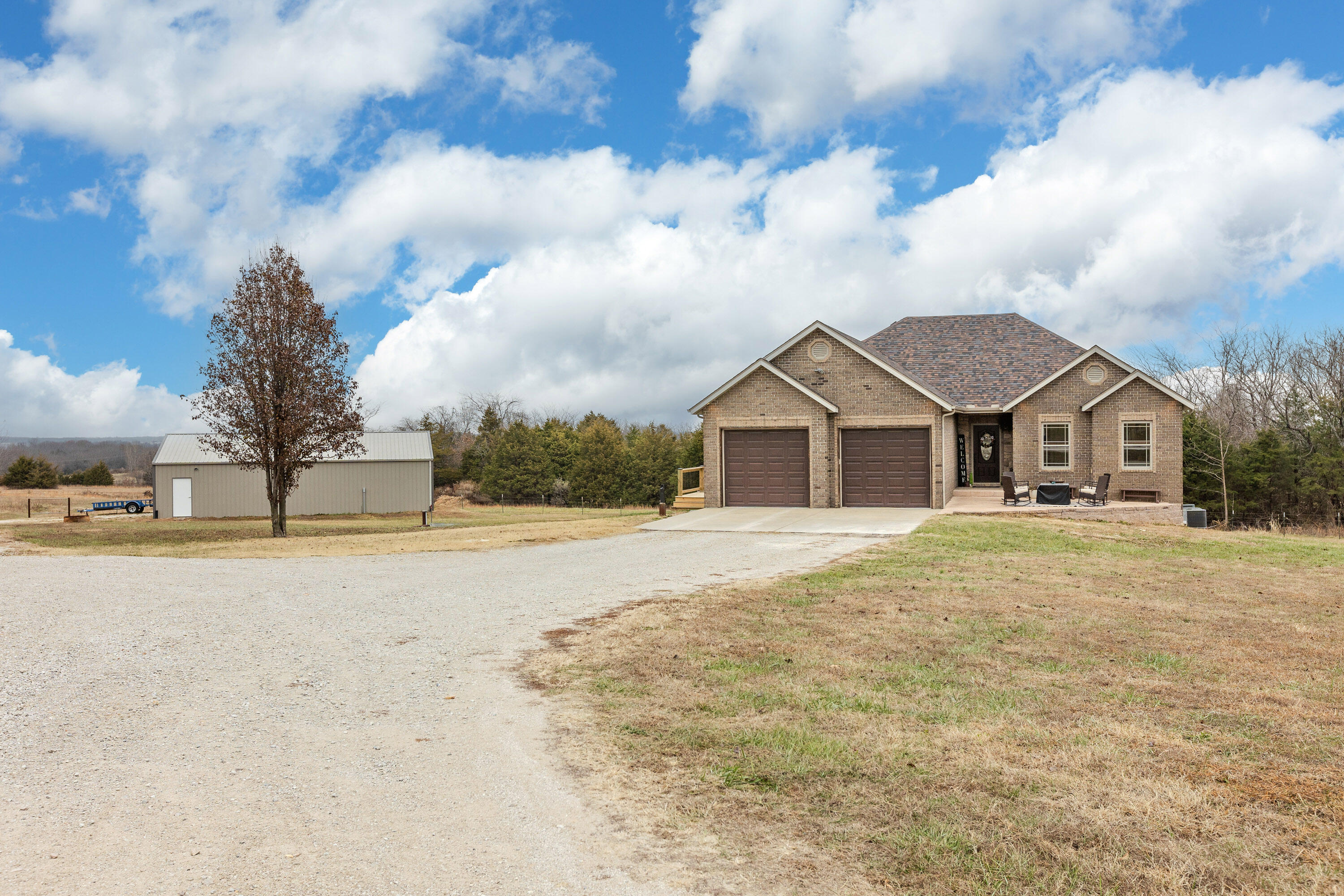 Gorgeous Walk-out Basement Home with Country Charm & Privacy sitting on 6.5ac just outside of Marshfield! Featuring over 3,300 sq. ft. of quality living space, 4 bedrooms, 3 full baths, two kitchens & dining areas, two laundry rooms, a partial covered deck and a 30'x48' shop with concrete floor! Upon entry you're welcomed by a neutral color palette, stunning teakwood hand scraped flooring, a wonderful living area with deck access and abundance of natural lighting! The kitchen/dining area features beautiful alder cabinetry with crown moulding & black hardware, granite countertops, undermount sink, breakfast bar, oversized tile and stainless/black appliances. The upstairs laundry is located just off the kitchen, with easy access to the garage entry. The Master is nicely sized, offering a full bath with jacuzzi tub, granite top, an amazing walk-in closet and deck access. There is one other bedroom found on the main, just adjacent to the hall bath. Downstairs you will find the second full kitchen, mechanical room/safe room, second living area, two additional bedrooms and the third full bathroom (4th bedroom is non-conforming as it has no window). This is an entertainers dream home! You are sure to be the hostest with the mostest and the place where all of your kids' friends & your family will want to gather! Stained concrete flooring makes this area easy to keep clean. This estate is made complete with an awesome 30x48' shop with concrete floor (currently being used for home gym), electric & water access. Private Well; Private Septic. Call today for your tour of this amazing property!