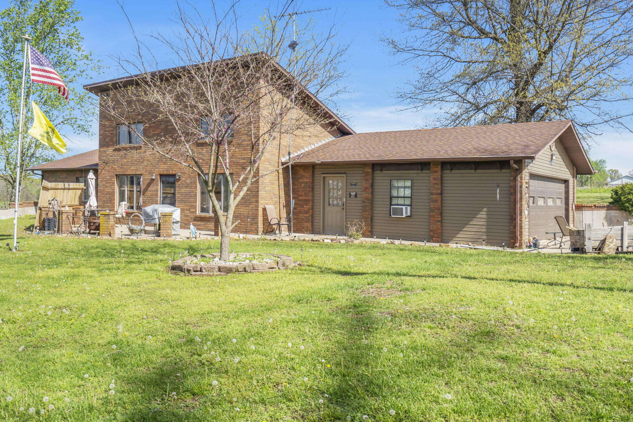 Discover this custom-built, all brick home on 1.7 peaceful, park-like acres overlooking a quiet arm of Honey Creek. Surrounded by mature trees, berm-style home offers a private, serene retreat. Inside, you'll love the soaring ceilings, huge windows, and stunning brick fireplace in the spacious living area--perfect for hosting or relaxing. The large custom kitchen features granite countertops, an island with cooktop, tons of storage, and a walk-in pantry. The primary suite includes a private bath and walk-in closet, and the entire home is stair-free for easy accessibility. Bonus features include a mudroom with sink, ideal for cleanup or extra pantry space, and a 24x30' shop building with concrete floors, bathroom, double 8' garage doors, and utilities. Efficient, beautiful, and ready for summer evenings on the patio. Don't miss out!
