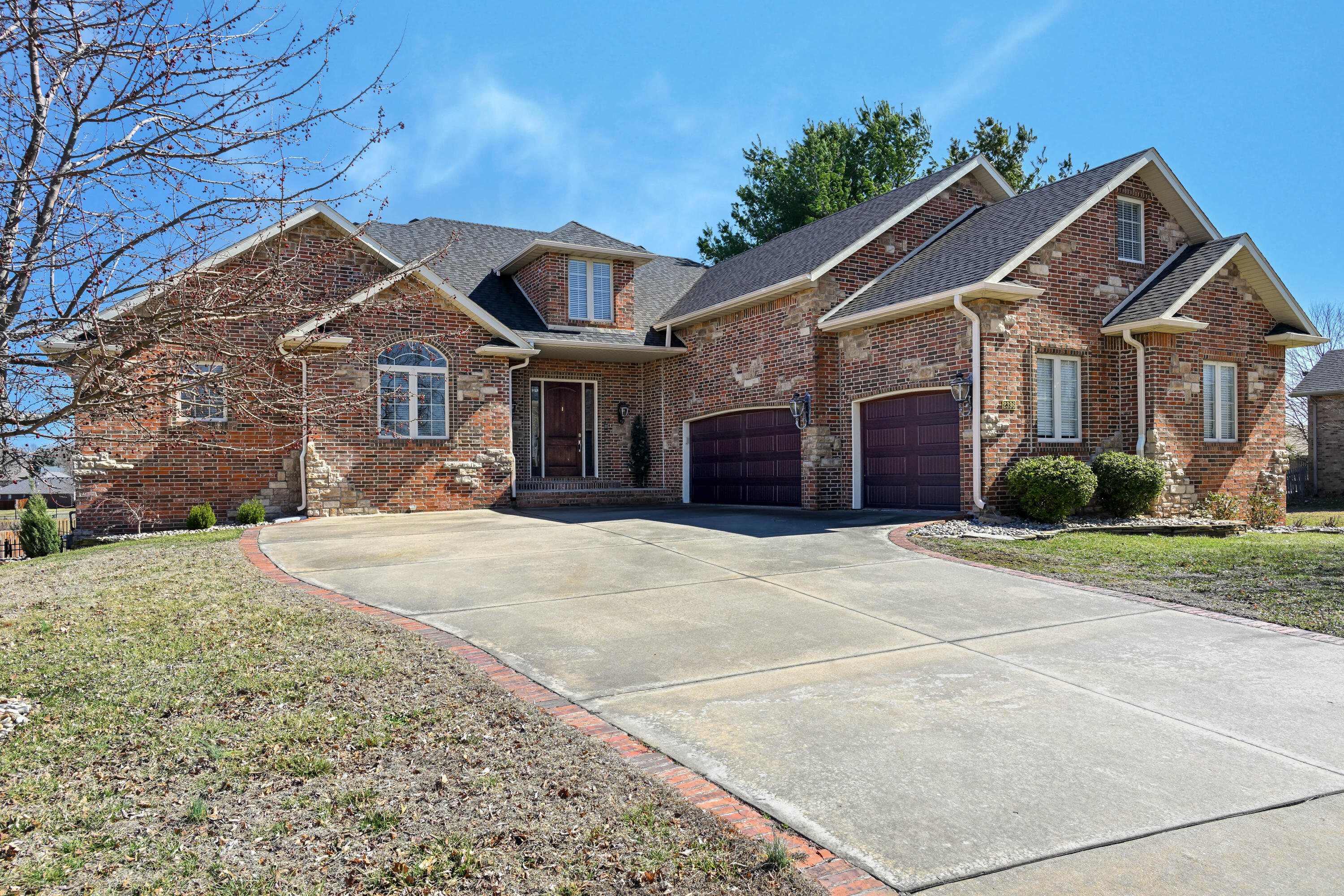 Welcome to this stunning all-brick home accented by stone, with custom quality amenities & beautiful finishings. This 2-Story Home with full walk-out Basement has 5 Bedrooms, 4 1/2 Baths & a 3-car oversized Garage providing ample space for all your needs. Enjoy multiple living areas throughout the Main Floor, Upstairs & in the Basement that promote plenty of room to relax, gather & create lasting memories. The Main Floor features engineered hardwood & tile flooring, 9' & 10' ceilings, crown molding & custom blinds. The beautiful Kitchen with adjoining Dining is quite spacious & includes lots of cabinets, a 5-burner gas Jenn-Air cooktop with overhead venting, a Jenn-Air built-in Microwave, Wall Oven & Warming Drawer. The Living Room features a corner gas log Fireplace with TV. Also on the Main Floor is a convenient Office with double door entry as well as the Laundry Room with built-in Coat Rack & ironing board. The luxurious Master Suite includes an adjoining Sitting Area that provides access to the covered back deck. Upstairs, you'll find 2 Bedrooms, each with their own private Bath PLUS a Large Family Room with TV included & lots of built-in hall linen cabinets. The finished Basement is an entertainer's dream with 2 additional Bedrooms, a Full Hall Bath + a wonderful Family Room with a Wet Bar & Recreation Area complete with a cozy corner gas log Fireplace. Also accessible from the Basement is the finished John Deere Room with double door access to the side yard. Custom touches are throughout adding to the home's distinctive charm. The outdoor space is equally impressive with a fenced backyard featuring both wood privacy & wrought-iron fencing.  This is a home that combines luxury, convenience & functionality in a way that's truly one of a kind!  Schedule a tour today to experience it for yourself.  NOTE:  NO HOA DUES but optional membership is available to the subdivision swimming pool within view of the back of the house & easily within walking distance.