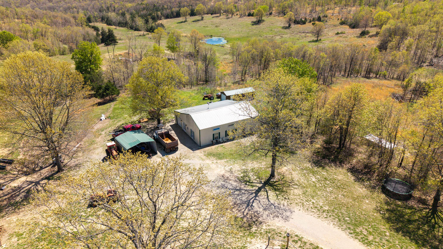 Ozarks perfection--107 breathtaking acres and a modern barndominium only 14 mi to West Plains and 18 mi to Thayer. A crystal&#8209;clear, year&#8209;round spring&#8209;fed creek ribbons across rich bottom pasture and feeds a deep spring pond ready for cattle, fishing, or a lazy kayak glide. Fertile soils grow lush, drought&#8209;tolerant grass; the farm is fully fenced, cross&#8209;fenced into 5 paddocks, wide steel gates, and lanes for easy stock moves, while scattered shade trees provide natural shelter. Hilltop meadows invite future building sites, and resident whitetail deer, turkey, and songbirds add free entertainment. Whether you run a serious cow&#8209;calf herd, board horses, or simply crave a private recreational retreat, this land is ready to perform. Behind its rugged steel shell, the barndominium feels light and luxe. An airy great room merges kitchen, dining, and living under soaring ceilings and picture windows framing your own pasture panorama. Scratch&#8209;proof LVP floors, custom cabinetry, and sweeping counters handle weekday meals or holiday crowds. The main level offers two generous bedrooms and a spa&#8209;sized bath with dual sinks, laundry niche, and deep storage. Upstairs, two non&#8209;conforming rooms flex for guests, office, studio, or kids' loft. Spray&#8209;foam insulation, efficient HVAC, and metal roofing ensure year&#8209;round comfort with minimal upkeep. Outside, a covered two&#8209;car carport links to a 48  12 powered lean&#8209;to, 12  30 shed, and 20  24 barn ready for tack, tools, and toys.Turnkey infrastructure, abundant water, and panoramic views make this move&#8209;in&#8209;ready spread a rare blend of production and pleasure--schedule your tour before this Ozarks gem is gone!