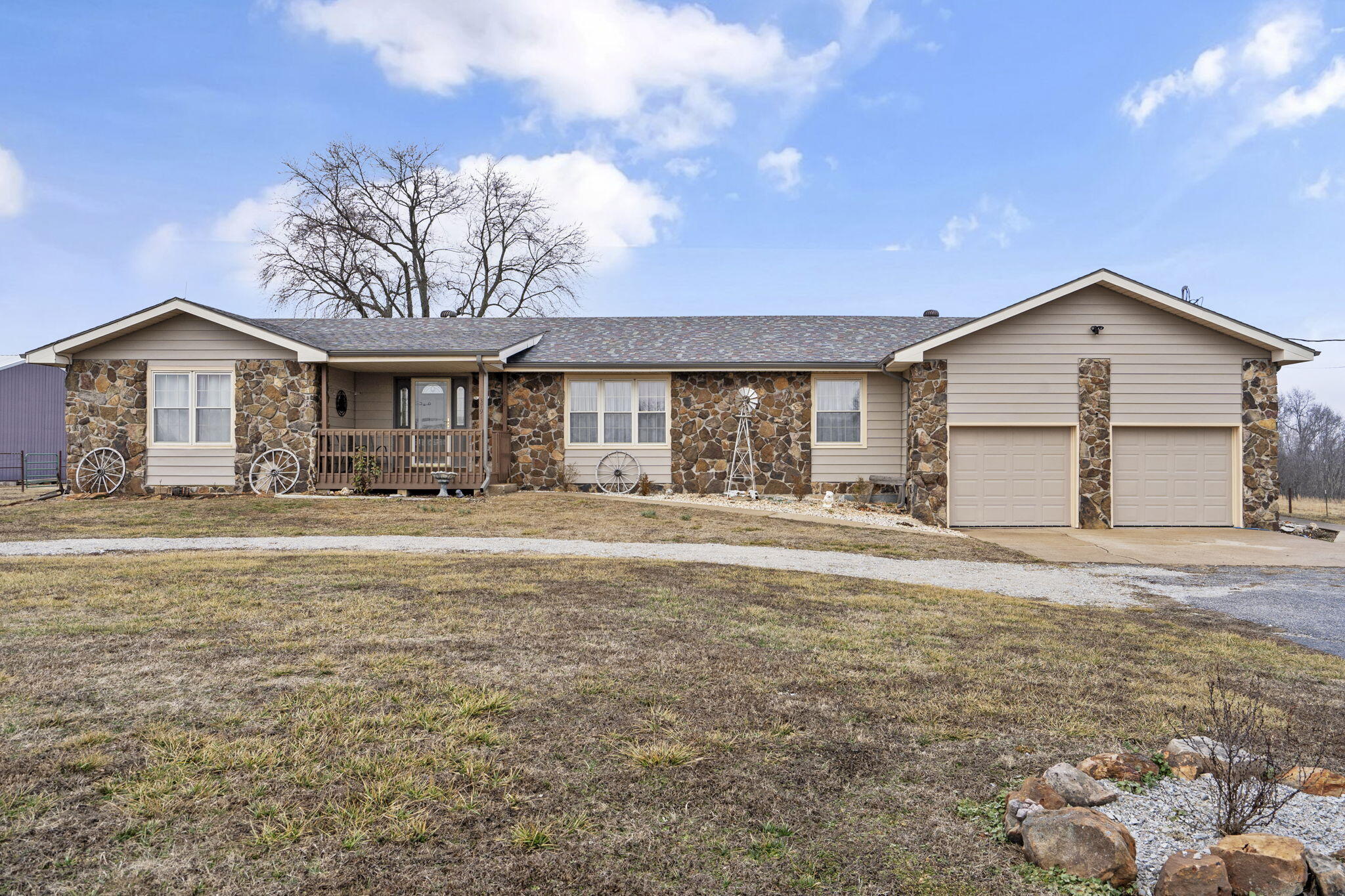 Updated 3 bed/2 bath basement home on 20 acres + a shop! Featuring an upgraded kitchen, bathrooms, luxury vinyl flooring, light fixtures, flooring, paint, roof (2021), HVAC, and more! The covered front porch invites you inside to a spacious living room with wood burning fireplace and access to the back deck. The kitchen offers painted cabinets, stainless appliances, subway tile backsplash, a bar for seating, and pantry. Off the kitchen is a formal dining room and laundry room. 3 bedrooms share 2 full hall bathrooms. The basement provides extra storage or living space and there is a 2-car attached garage. Outside, you will love a freshly stained deck, new fencing, and gorgeous prairie views. There is an impressive 40x60' shop with concrete floors, garage doors, and a tack & feed room that's perfect for cattle or horses. In addition, there is a 12' lean-to and storage shed. Many opportunities to start a hobby farm and to bring your cattle, horses, goats, or chickens. Enjoy the best of both worlds--embracing the peace of country living--while being just 20 minutes from Springfield/Nixa conveniences and only minutes from James River, Two Rivers Mountain Bike Park, and 45min to Table Rock Lake.