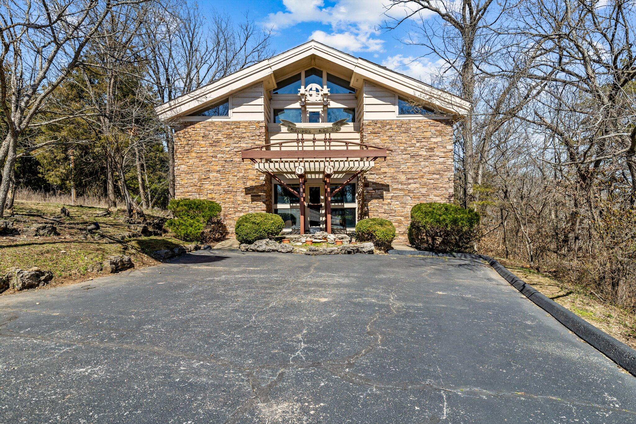 PRIME LOCATION! This exceptional commercial building is situated on a VERY RARE 1.9-acre lot near downtown Branson offering convenient access to both the Branson Landing and Lake Taneycomo, as well as US Hwy 65. This unique three-level building includes many custom features throughout. The exterior is covered with stone and wood siding, there are also many large windows that optimise the natural lighting inside the building & the roof is covered with wood shake shingles. The main level features a workstation near the front door, a conference room with a scenic view of the property, a private office, a lounge area with a break room, 2.5 bathrooms and multiple storage rooms. Head upstairs & you will find four additional office spaces, another conference room with scenic views of the property and a large open-concept work area with four additional workstations. The basement offers approximately 300 square feet of storage space with a concrete floor with plenty of additional unfinished space to convert to more storage area. Outside you will find a paved parking area in front of the building with easy access to the street and just down the street there is an additional road cut-in providing the ability to add additional parking spaces behind the building if needed. The majority of the 1.9-acre lot is wooded, attracting an abundant amount of wildlife including whitetail deer & turkey. This property represents an ideal opportunity, whether you are starting a new business, expanding your current operations, or if you are wanting to invest in a prime real estate location. Don't wait, an opportunity like this one doesn't come around often & it won't last long!