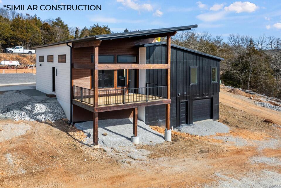 This brand new home is just a short easy walk to the community's amenities, has a great lake view and is still just a gentle sloping walk to Table Rock Lake!  The modern selections of this unit include granite countertops, luxury vinyl plank flooring, custom built cabinets, modern black lighting/plumbing fixtures, vaulted ceilings, open floor plan and large windows to not miss out on the picturesque views of Table Rock Lake. The exterior gives off some edgy vibes with their sharp, clean lines and bold colors, finished with a covered deck and metal railing.  There's even a one car (or golf cart) garage and enormous walk-in crawl space to store all your lake toys! The community features a swimming pool, pavilion, space for yard games, a children's play area, a rock climbing wall, outdoor fireplace, and 2 boat docks with slips available for purchase! The best part of all is that your grounds maintenance is completely taken care of, all you have to do is come and enjoy the lake and all the Branson, Missouri area has to offer.These units are zoned for nightly rental so they are perfect for investment or just to help pay for that lake home you've always wanted!