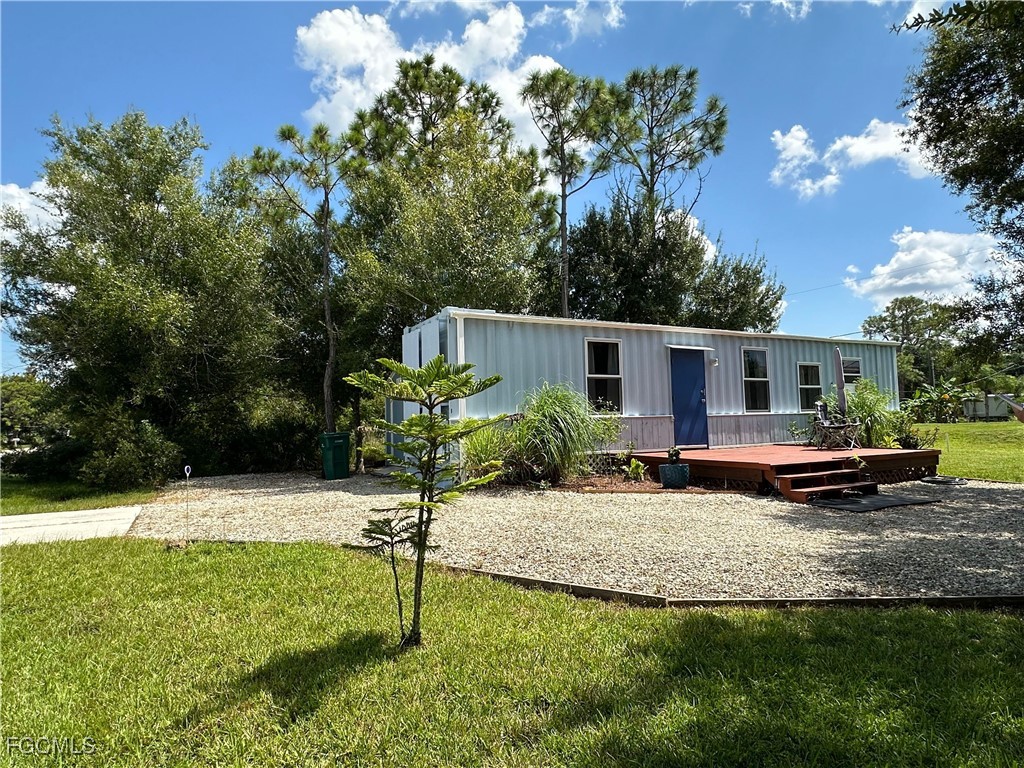 Rear view of house with a yard and a deck