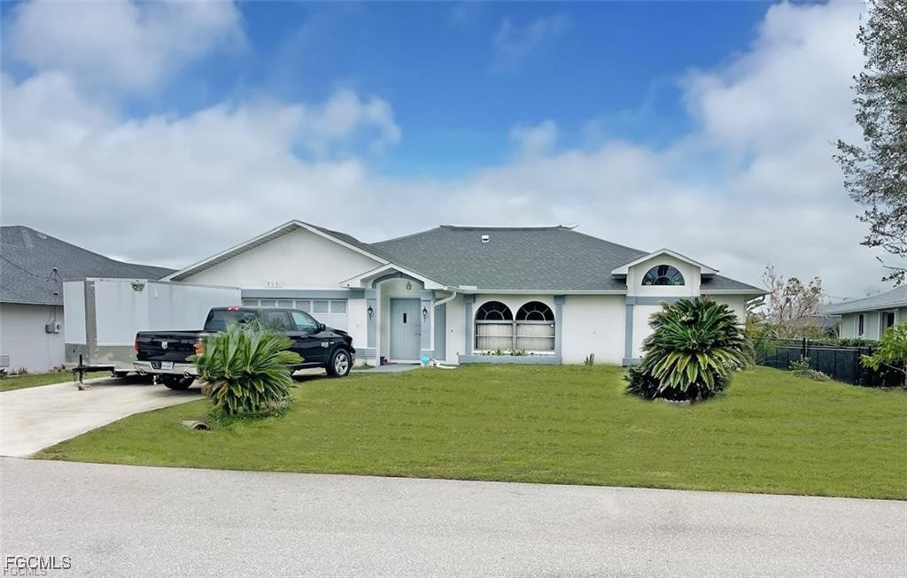 Single story home featuring driveway, stucco sidin