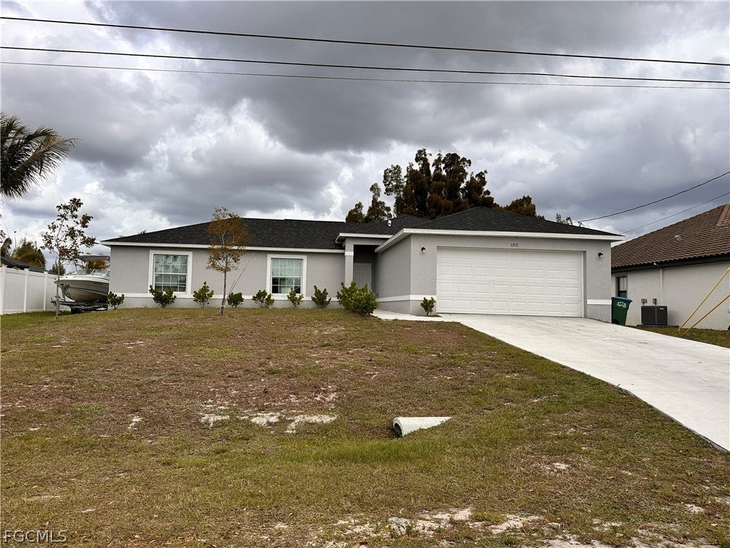 Ranch-style home with a garage, stucco siding, con
