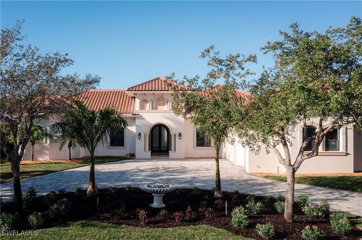 Mediterranean / spanish home with french doors, curved driveway, and stucco siding