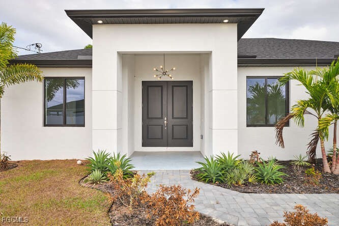 Entrance to property featuring stucco siding and r