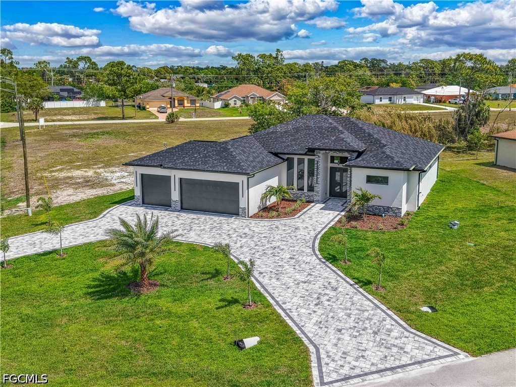 View of front of house with decorative driveway, a