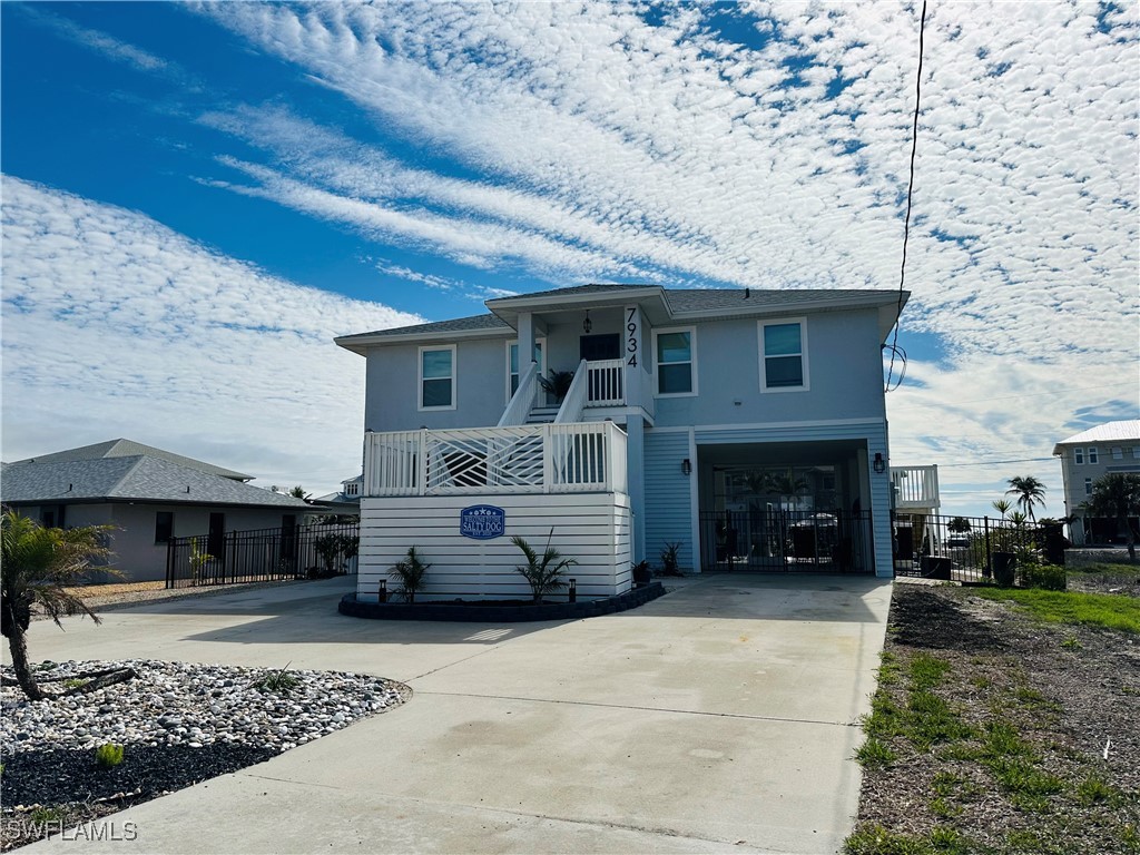 View of front of property featuring driveway, a ba