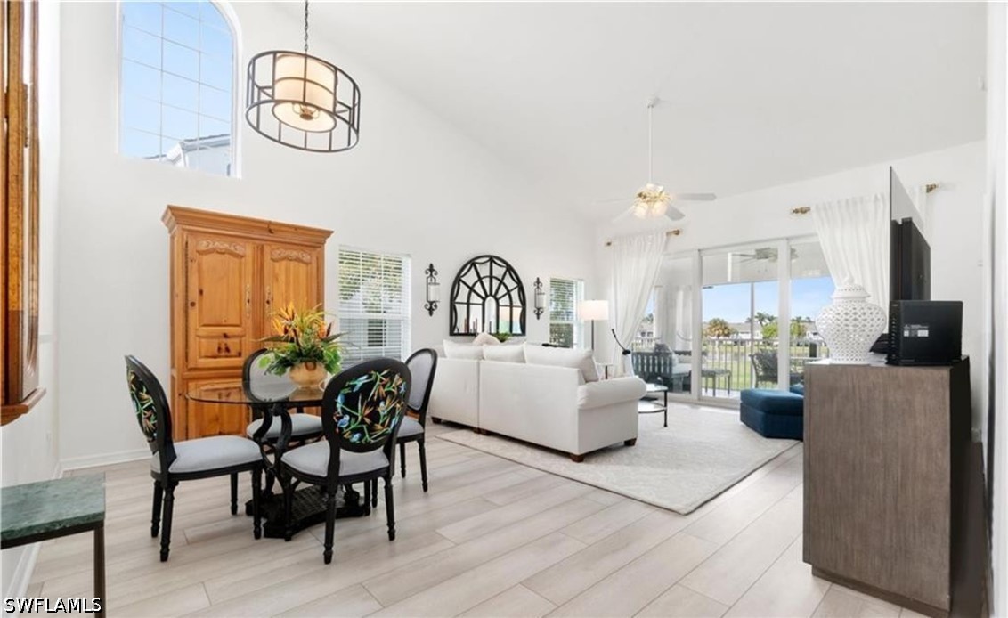 Dining room featuring ceiling fan, high vaulted ce
