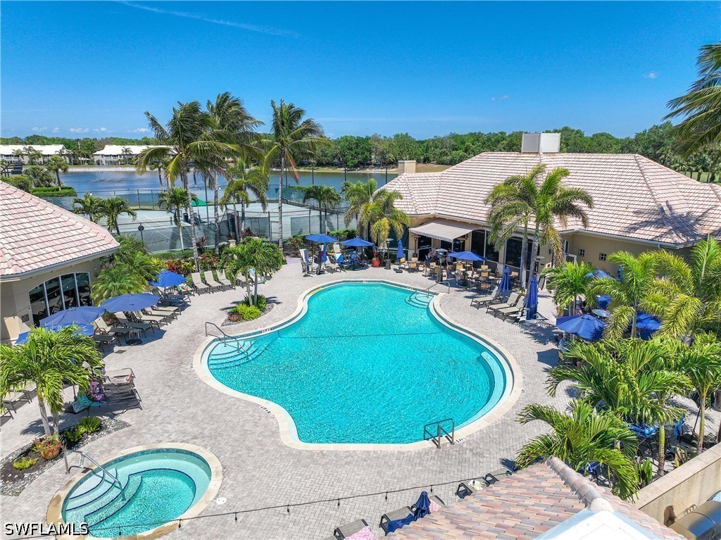 Community pool with a patio area, a water view, an