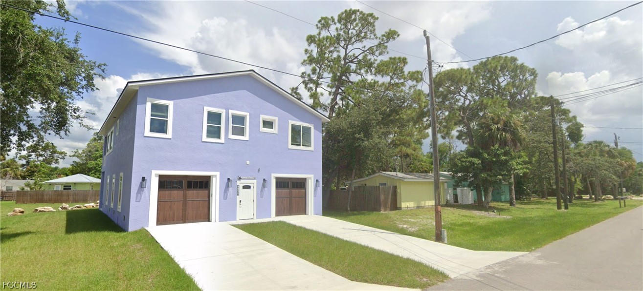 View of front of house with stucco siding and driv