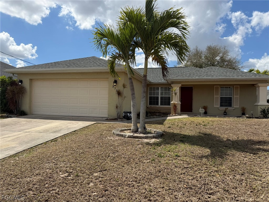 Ranch-style house featuring stucco siding, a garag