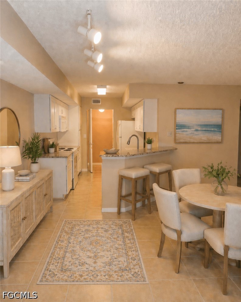 Open-concept kitchen and dining area featuring til