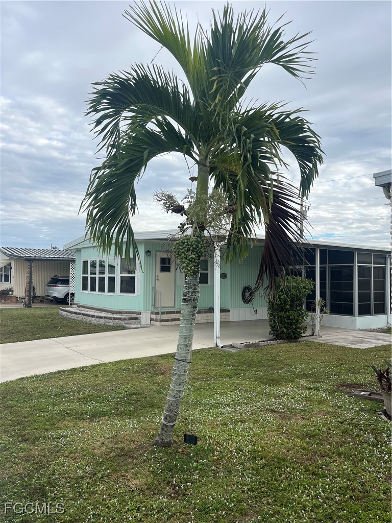 View of front of property featuring a sunroom, a f