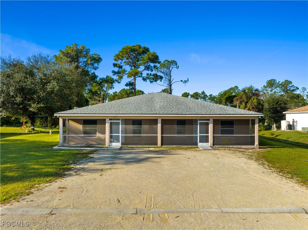View of front of house with a front lawn, a sunroo