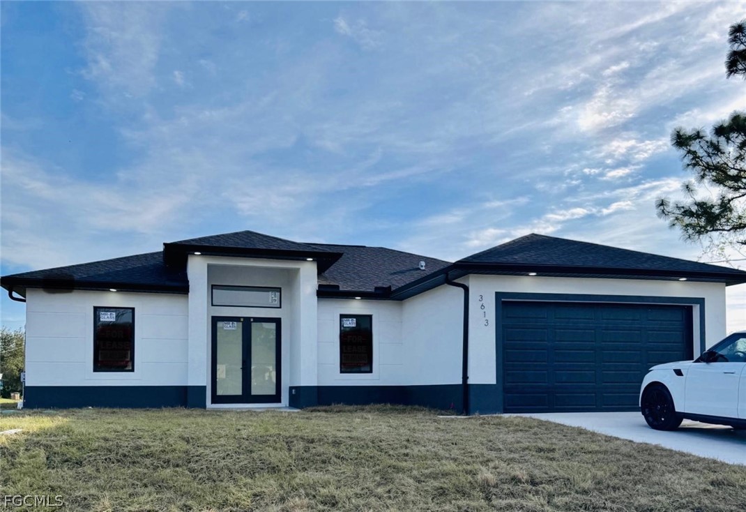 View of front of house with a front lawn, roof wit