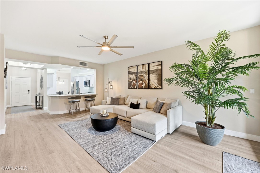 Living area with light wood-style flooring and cei