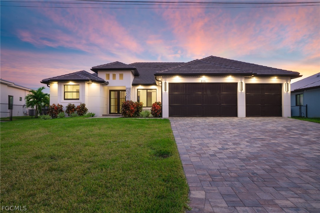 View of front of home with a garage, driveway, stu