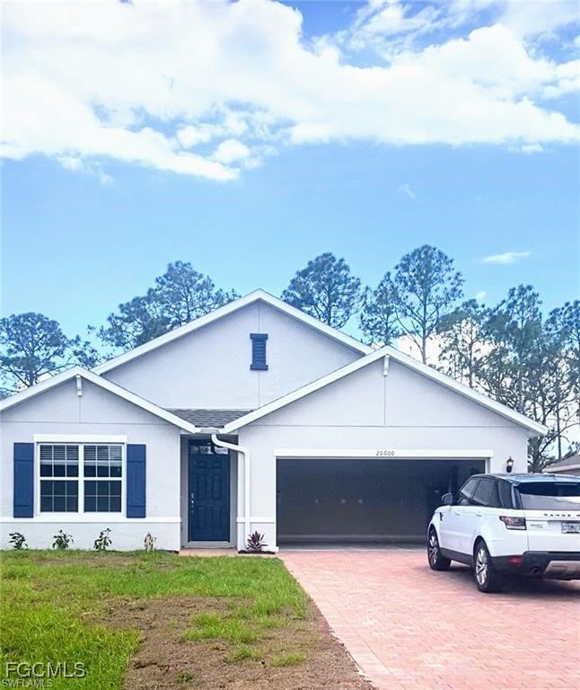 Single story home with decorative driveway, a gara