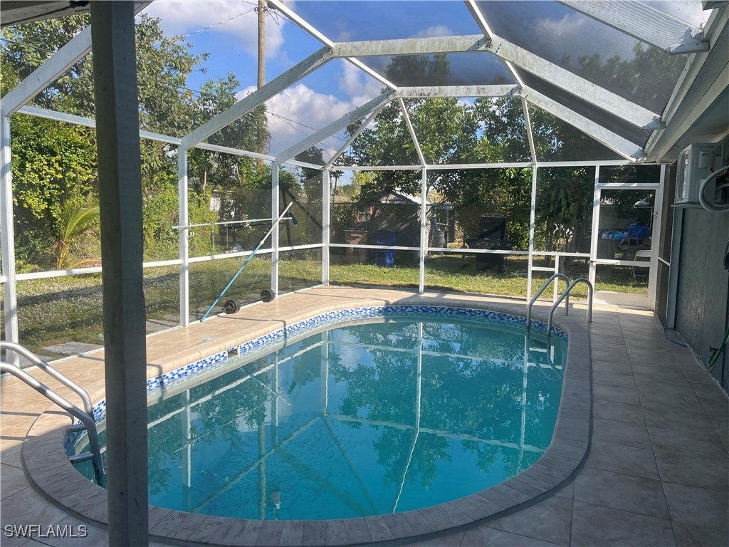 Swimming pool featuring a sunroom, a lanai, and a