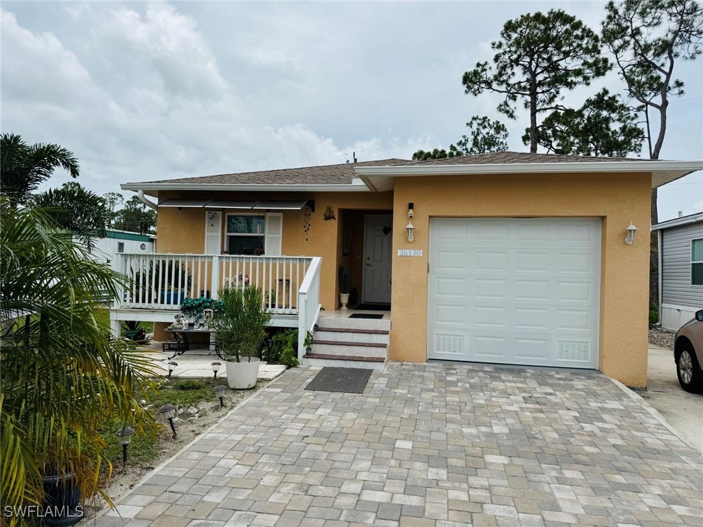 View of front of home with stucco siding, a garage