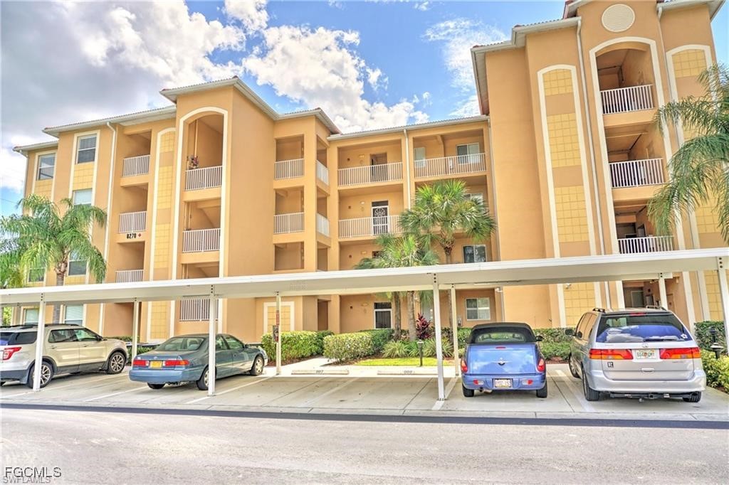 View of apartment building / complex with covered
