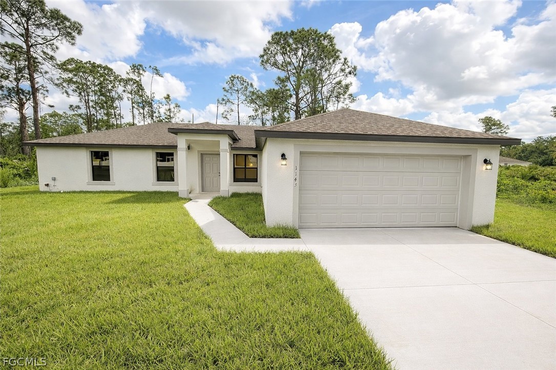 View of front of property with a front yard, concr